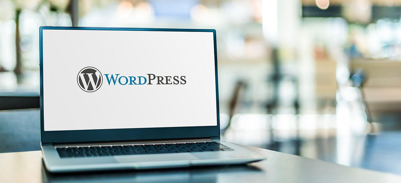 這張圖片展示了一台筆記型電腦,螢幕上顯示著「WordPress」的標誌,這是一個常見的網站內容管理系統。背景模糊,聚焦於電腦螢幕,強調WordPress作為網站設計和管理工具的專業性和易用性。